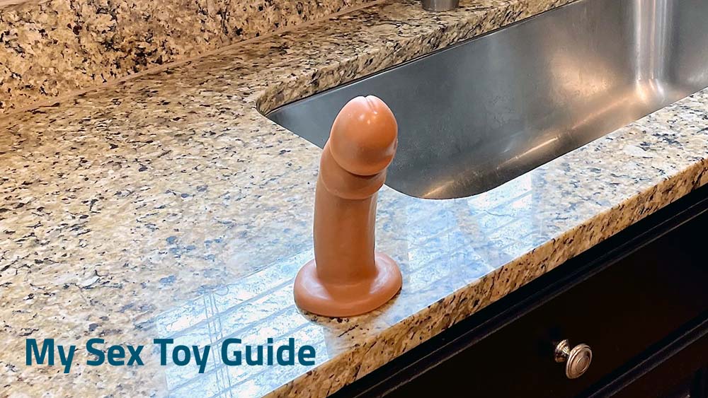 Vixskin Maverick suction cup dildo attached to a kitchen sink counter